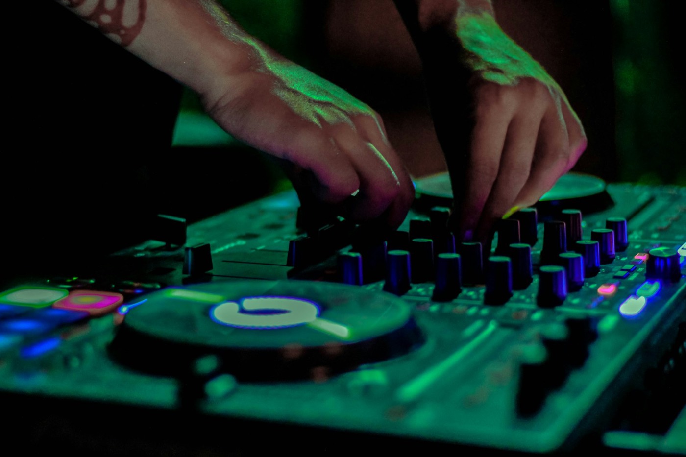 DJ-H&auml;nde am Controller und Mixer w&auml;hrend einer Party